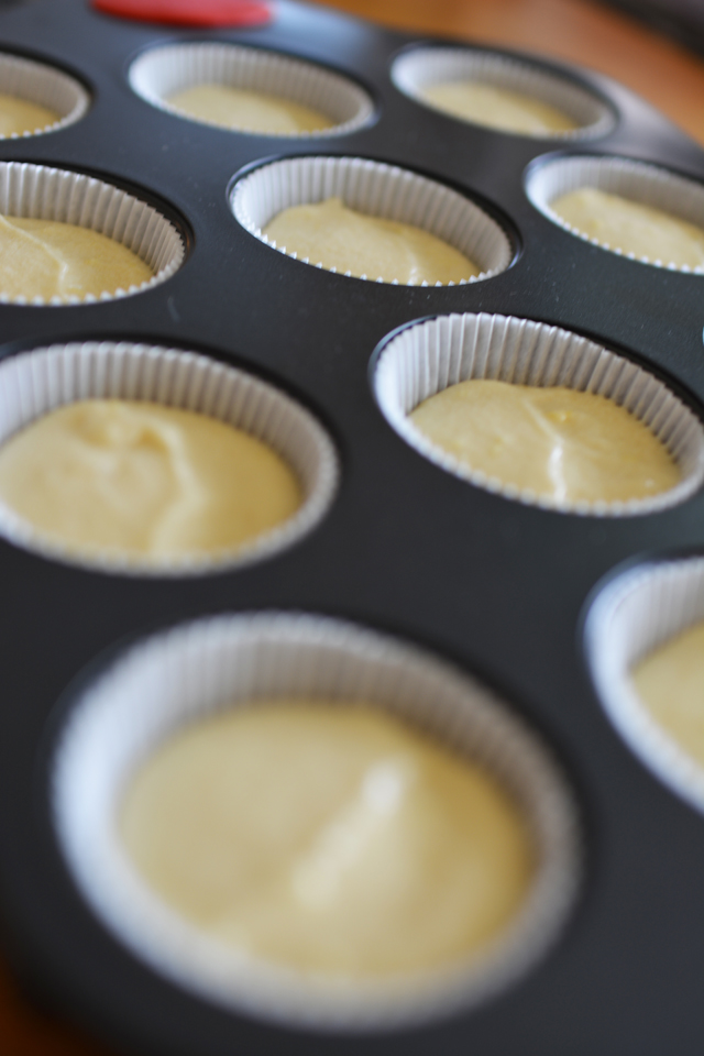 An image of uncooked muffins in a muffin tin captured from a slanted angle