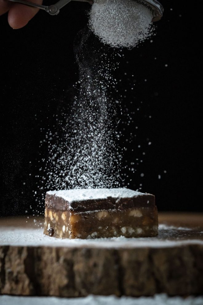 Photo of sprinkling powdered sugar on brownie bar, photograph by Lauren Caris Short of Food Photography Academy
