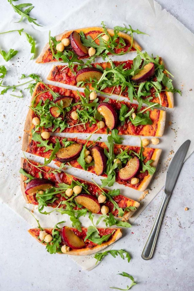 Flatlay of a flatbread with peaches, tomato sauce and arugula, photograph by Lauren Caris Short of Food Photography Academy"