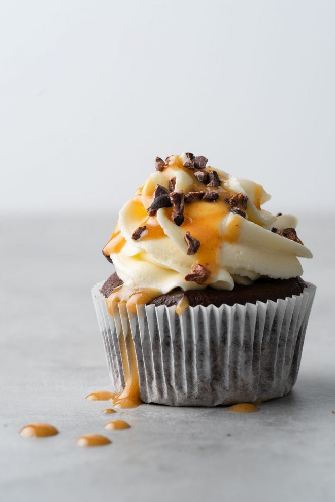 Chocolate cupcake with white frosting, caramel sauce, and chocolate and walnut sprinkles, photograph by Lauren Caris Short of Food Photography Academy