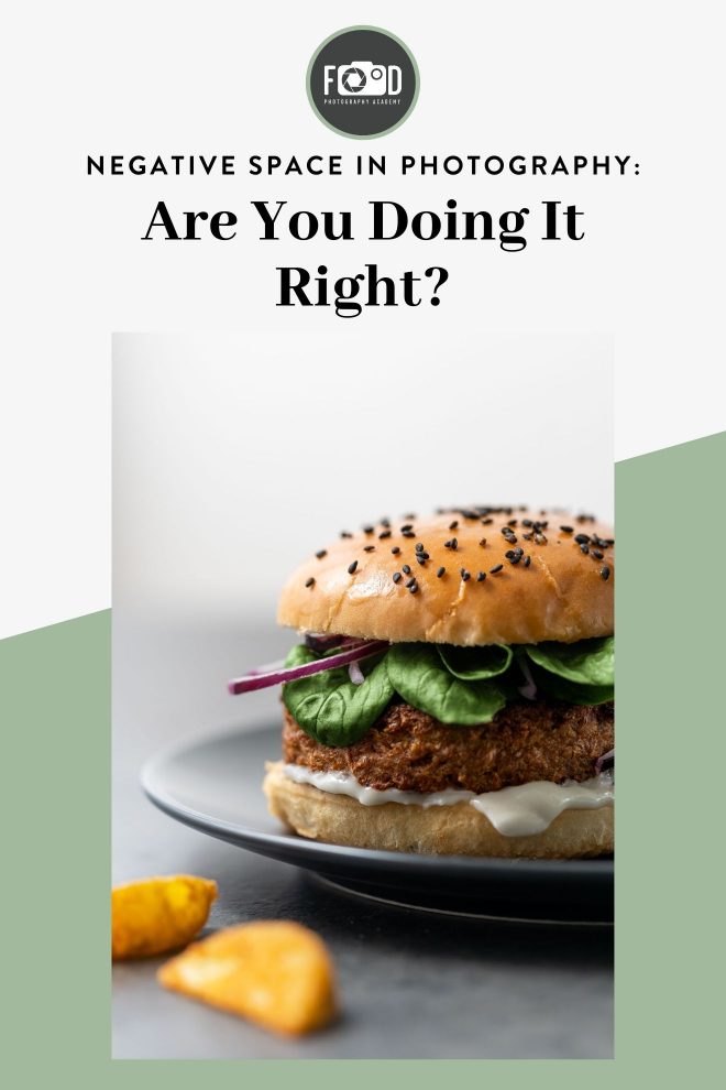 Close up shot of a cheeseburger set against a white-gray background. Text on mage reads "Negative Space in Photography: Are you doing it right?" Photograph by Lauren Caris Short of Food Photography Academy.