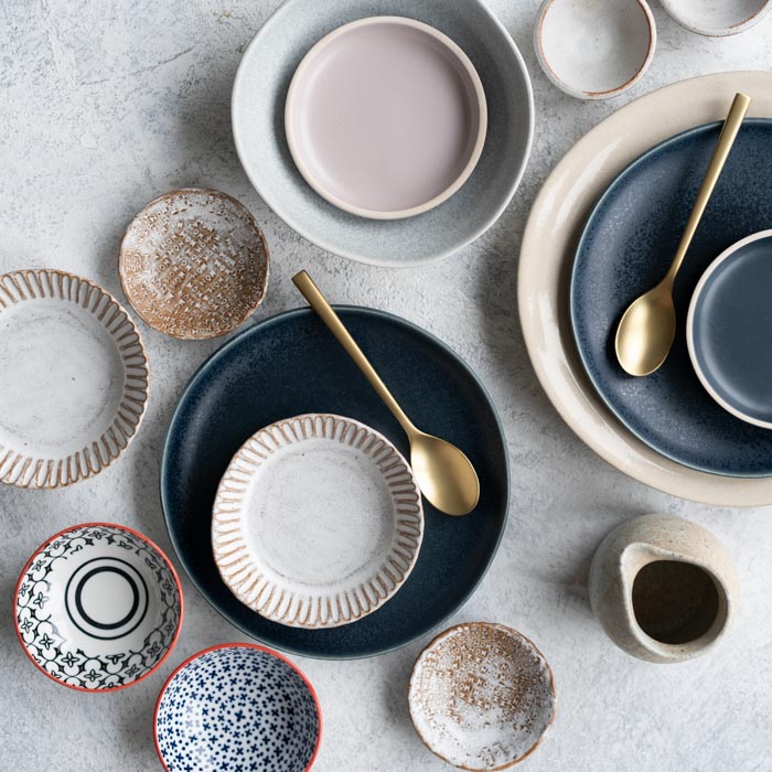 an assortment of places and bowls sit on a countertop
