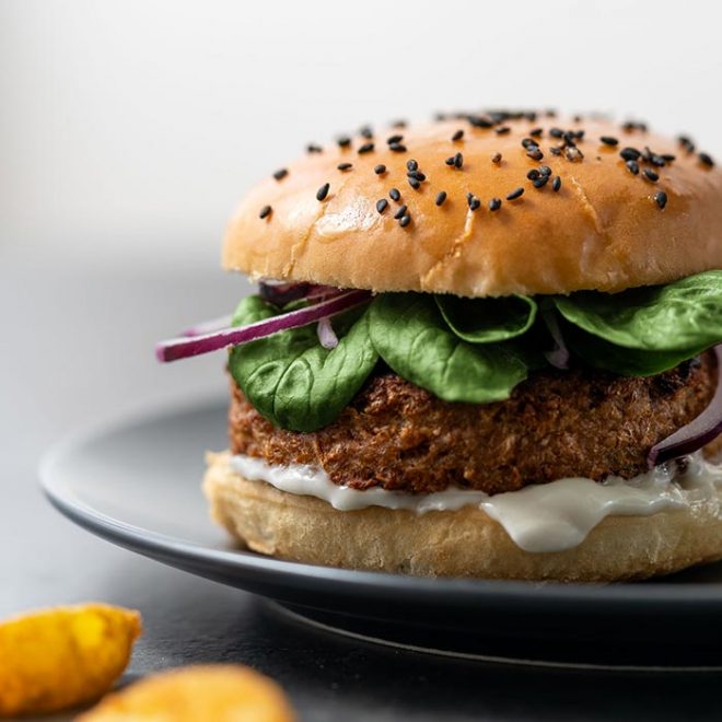 a vegan burger rests on a plate