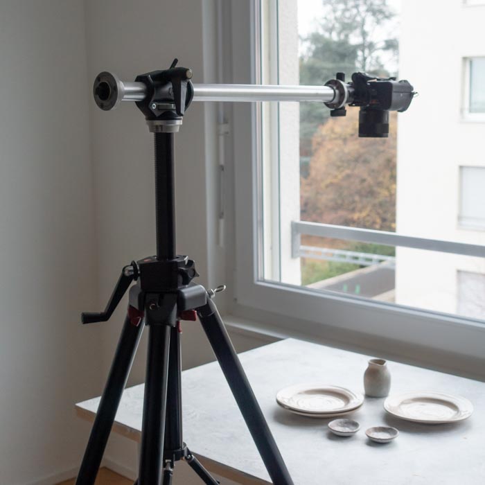 a tripod is set up with a camera that hovers over a display of food